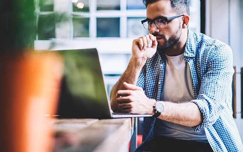 man sitting looking at laptop in printer services office