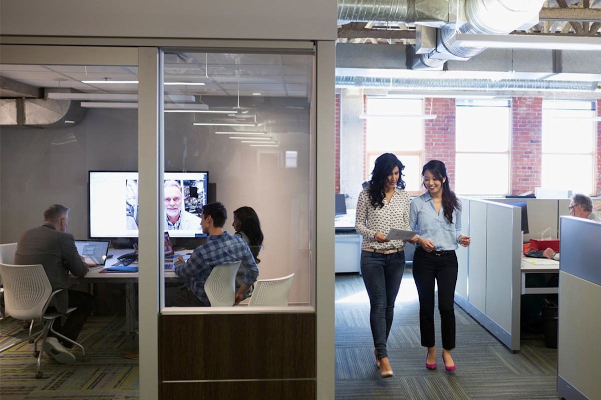Modern office environment with employees working and collaborating, supported by managed print services